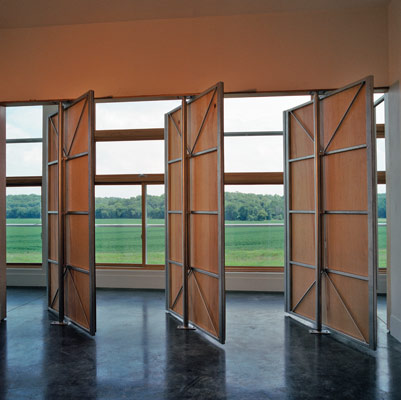 In one of the guest bedrooms, custom steel partitions open the entire wall to the southern view and the length of the north hall. The flexible space is at the heart of the core area and can be changed immediately from an open studio space to two smaller bedrooms, as needed. 'In our projects, we increasingly provide less definition for what the end use of a room should be,' Rockhill says. 'We provide rough space as opposed to delineating with great specificity where activities should occur.'